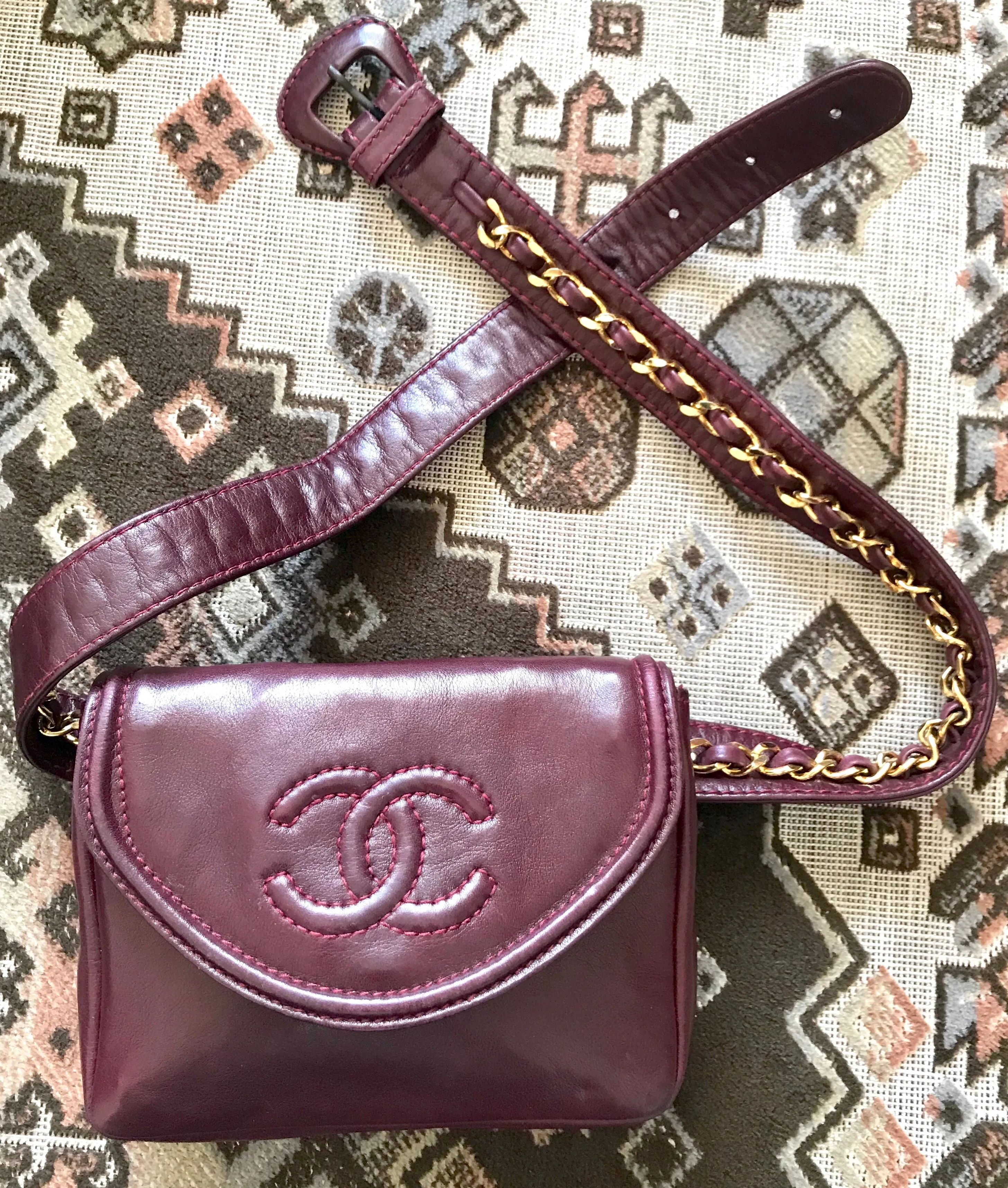 Vintage CHANEL wine fanny pack, leather belt bag with detachable chain belt and CC stitch mark on flap.  Fits 29.5" -32.6"