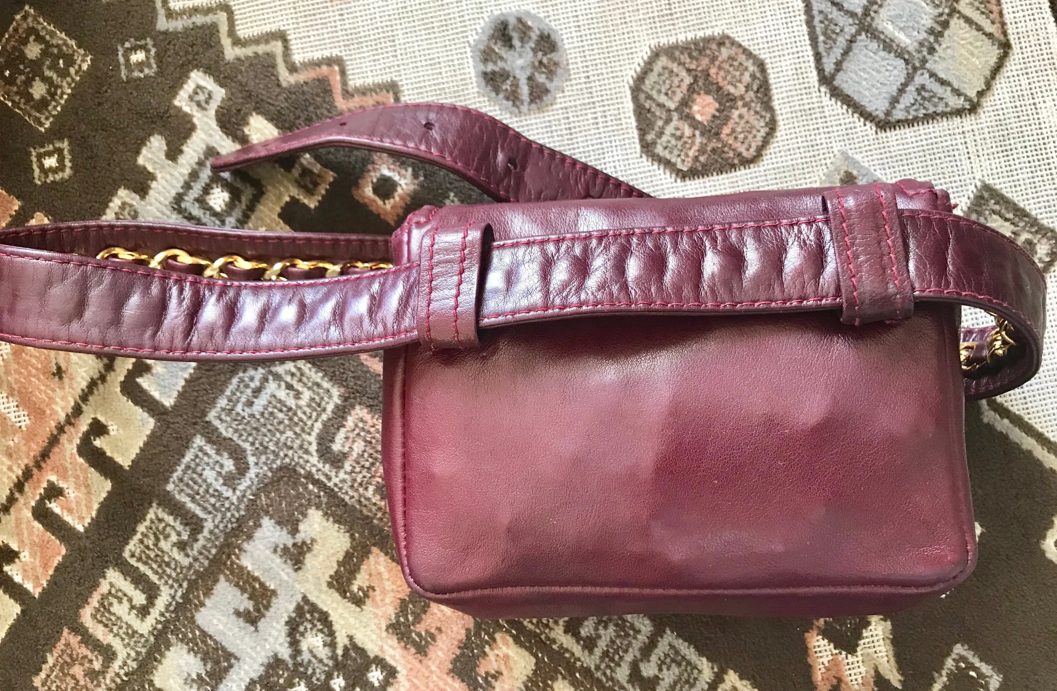Vintage CHANEL wine fanny pack, leather belt bag with detachable chain belt and CC stitch mark on flap.  Fits 29.5" -32.6"