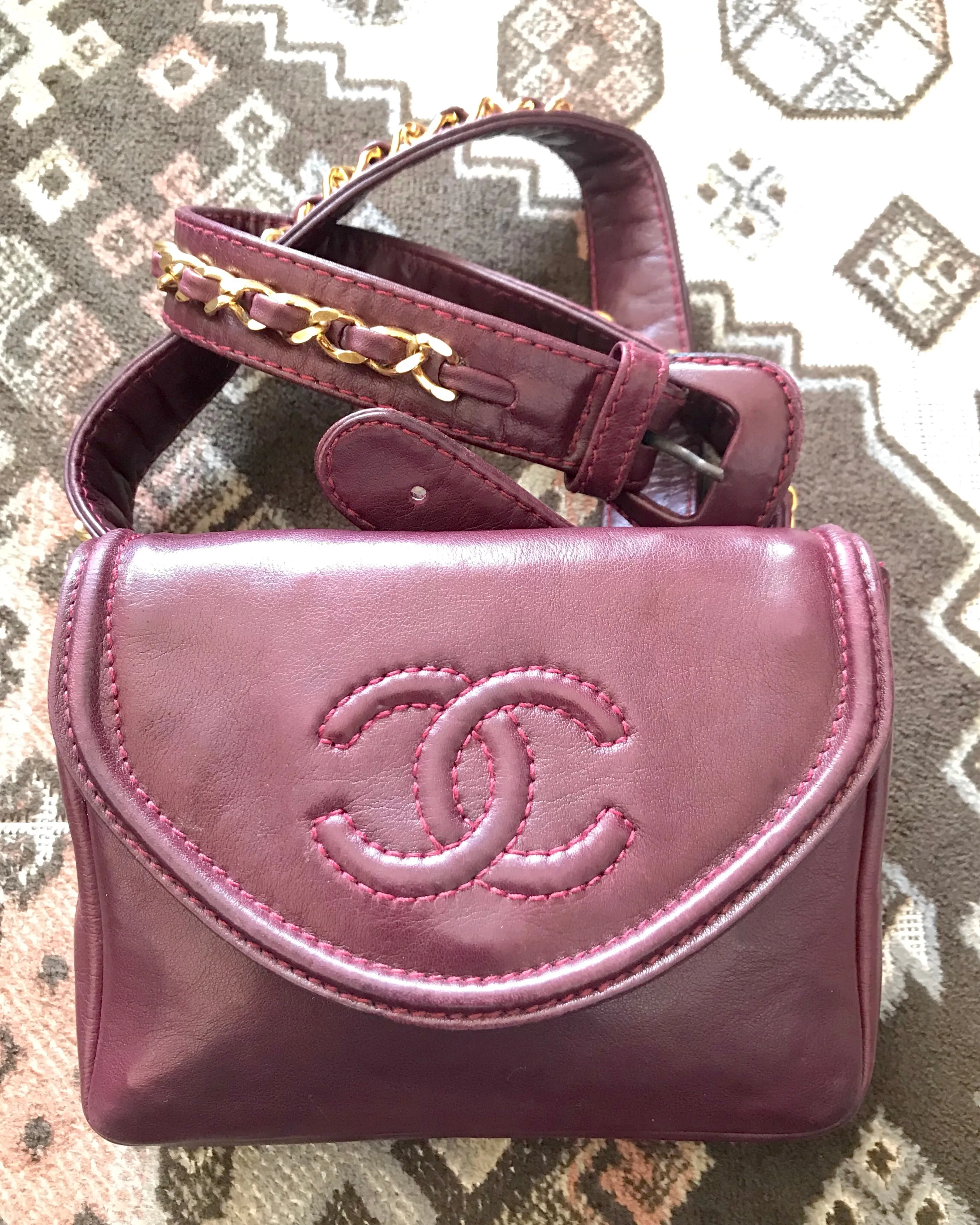 Vintage CHANEL wine fanny pack, leather belt bag with detachable chain belt and CC stitch mark on flap.  Fits 29.5" -32.6"